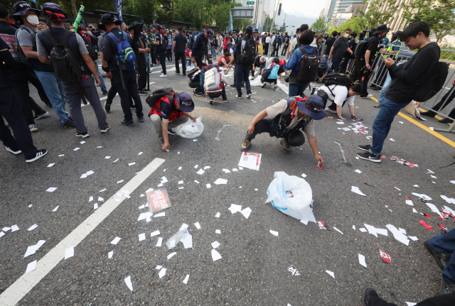 31일 서울 세종로에서 윤석열 정부의 퇴진을 요구하는 민주노총 집회가 열린 가운데 경찰의 해산 명령 후 주간 집회를 마친 노조원들이 쓰레기를 치우고 있다. 지난 16~17일 노숙 집회의 쓰레기 투척, 노상 방뇨와 술판 등에 대한 비판을 의식한 것으로 보인다.  연합뉴스